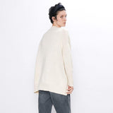 Femme portant un pull long blanc.
