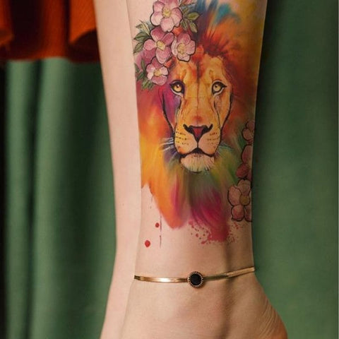 Tatouage lion couleur sur bras.
