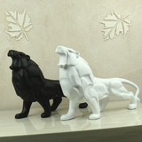 Deux statues de lion en résine noire et blanche.