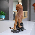 Statue lion marron sur socle.