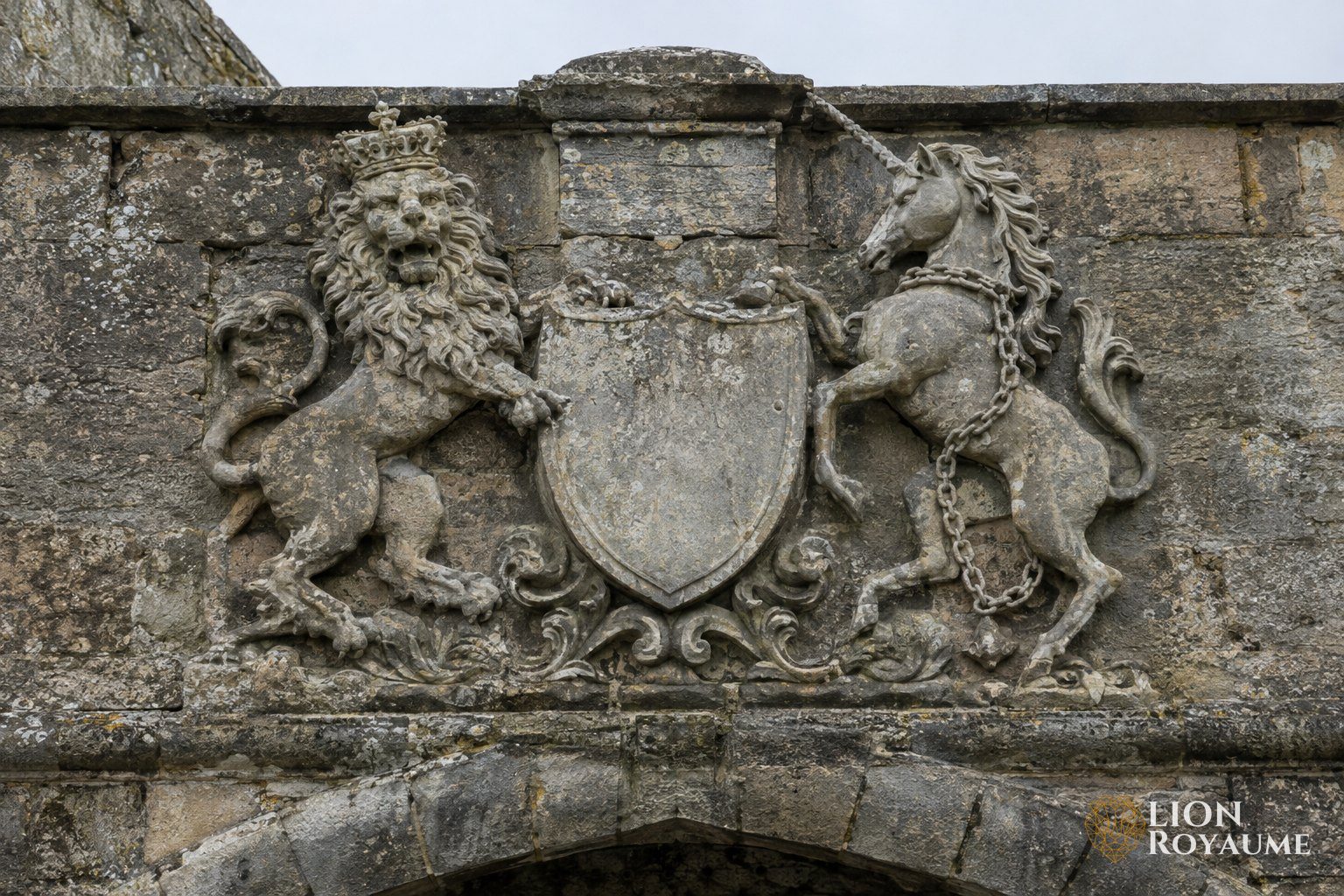 Bas-relief en pierre d'un lion couronné et d'une licorne de chaque côté d'un écu